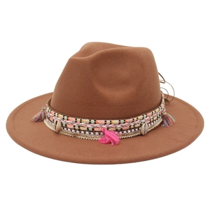 Close-up of brown wool fedora featuring bohemian tassels, shells and woven band detail