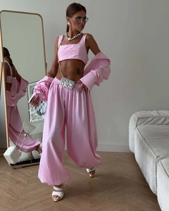 Detail view of pink striped three-piece set with crop top, shirt and loose trousers