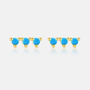 Close-up of gold S925 silver stud earrings with three round turquoise blue zircons