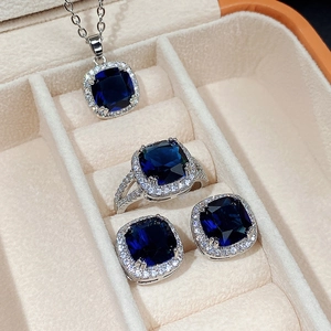 Elegant silver jewelry set featuring square sapphire blue stones in a beige gift box