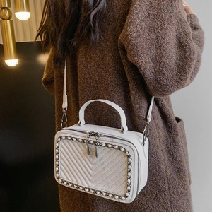 Elegante borsa a scatola bianca con trapuntatura a V e tracolla a catena indossata da modella
