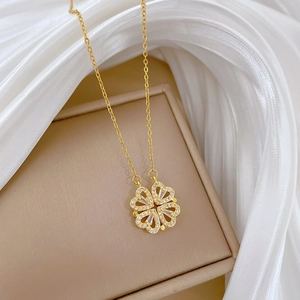 Detail of clover pendant with sparkling crystals on gold necklace and beige jewelry box