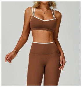 Detail view of brown V-neck sports bra and high-waist leggings with white piping