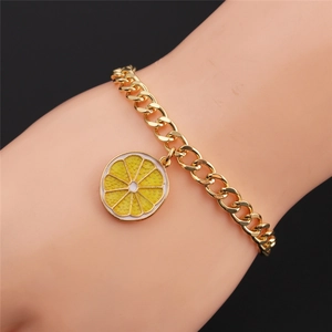 Detail of gold-plated bracelet featuring a yellow enamel lemon slice fruit charm