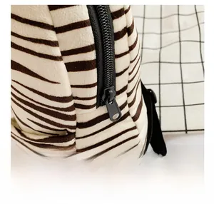 Detailed close-up of the smooth black zipper and striped plush fabric of the kid backpack