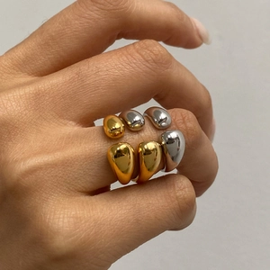 Detail of minimalist mixed-metal teardrop rings in polished gold and silver finishes