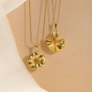 Elegant gold stainless steel sunflower and wavy petal pendant necklaces on soft fabric