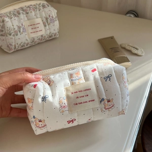 Close-up of quilted cotton cosmetic bag featuring cute cat patterns and zipper closure