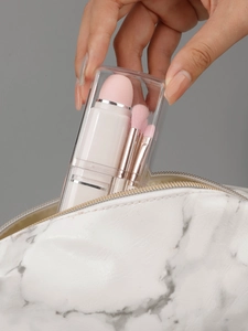 Detail of compact 8-in-1 pearlescent makeup brush set with a pink sponge in a clear case