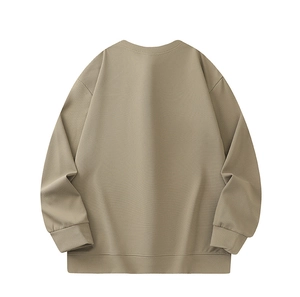Detail of the khaki crewneck sweatshirt showing loose fit drop shoulder and ribbed cuff texture