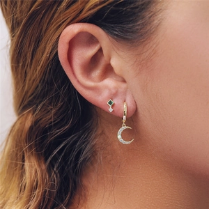 Close-up of S925 silver gold earrings with green gemstones and crescent moon charms