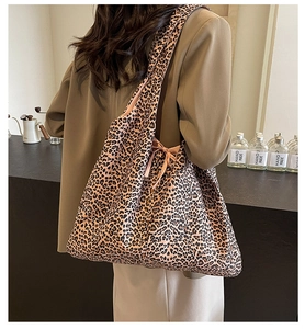 Detailed view of large leopard print tote bag with bow detail on a fashion model