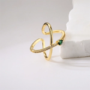 Macro detail of gold open ring featuring a green teardrop stone and zircon inlay