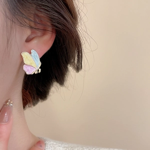 Detailed view of enamel butterfly stud earring with pastel blue, yellow and pink segments