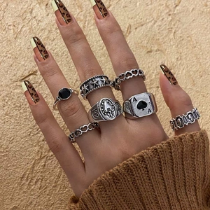 Detailed close-up of gothic skull and bat rings on hand with leopard print nails