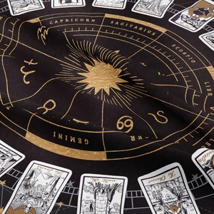 Close-up of bohemian wall tapestry featuring gold zodiac wheel and tarot card details
