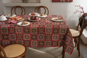 Close-up of red jacquard tablecloth with ethnic geometric patterns and wavy edges