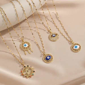 Golden Evil Eye necklaces set with blue enamel and sparkling zircons on silk background