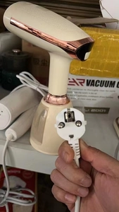 Detail van de Europese stekker en het snoer voor handstomer in crèmewit met roségouden accent
