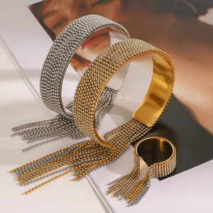 Detailed view of stainless steel tassel bangle and ring with gold and silver bead texture