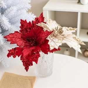Detail of red and champagne poinsettia flowers with sequins in a glass vase