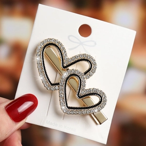 Detail of Korean double heart hair clip with black enamel and white crystals
