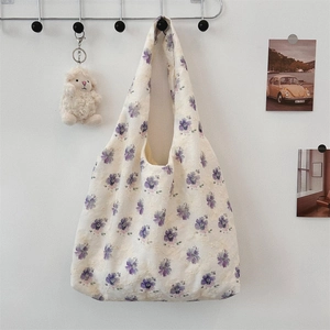 Detail view of purple floral embroidery on cream canvas tote bag with rustic card decor