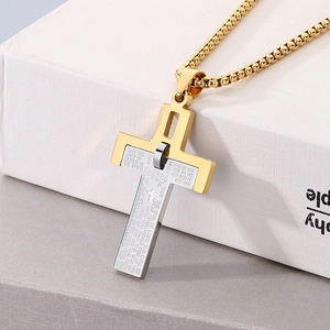 Macro detail of two-tone stainless steel cross pendant with engraved Lord's Prayer text