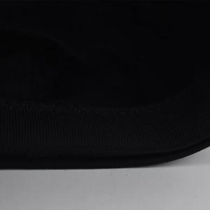 Close-up of the high-elastic black knit texture and flat sewing edges on the beret