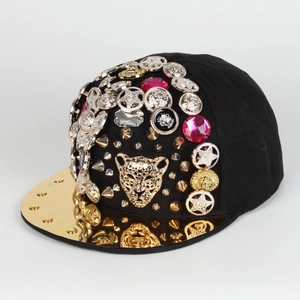 Close-up of golden leopard head relief with sparkling rhinestones and studs on a hip-hop hat