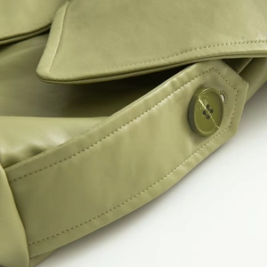 Detailed close-up of avocado green leather jacket lapel with fine stitching and button