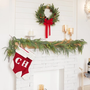 Christmas fireplace set with pine wreath, pinecone garland, and red knit stockings