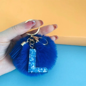 Blue faux fur pompom keychain with glitter letter L pendant and tassel on gold hardware