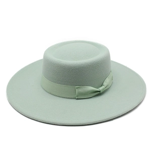 Detail of mint green wool fedora hat featuring a matching ribbon bow on wide brim