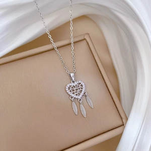 Collana acchiappasogni a cuore argento con piume su sfondo di seta bianca