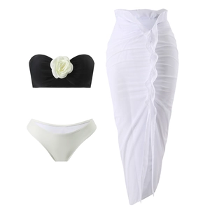 Detailed flat lay of a 3-piece bikini set with 3D white roses and matching mesh skirt
