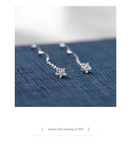 Vista macro di orecchini a stella in argento S925 con nappe e zirconi cubici scintillanti