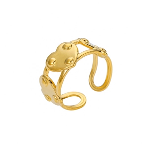 Macro view of gold heart ring with dotted relief texture and open adjustable band