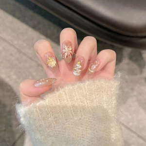 Close-up of festive Christmas press-on nails with golden trees and 3D snowflake details
