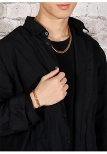 Detail view of a men's 8mm gold-tone stainless steel Cuban link chain necklace and bracelet