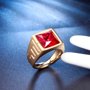 Close-up of golden stainless steel ring featuring a square-cut red gemstone inlay