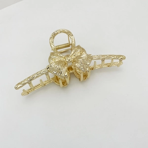 Detail shot of the golden alloy butterfly hair claw clip with textured metallic finish
