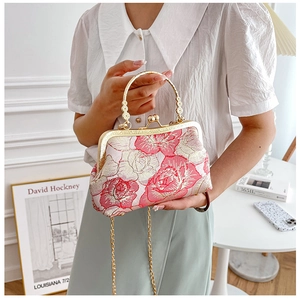 Detailed pink floral embroidery on a mini qipao evening bag with pearl handle and chain strap
