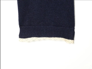 Close-up of the fine knit navy blue cardigan with white lace trim at the hem and cuffs