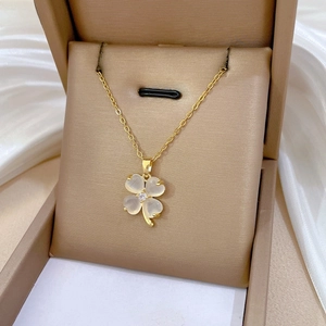 Macro shot of lucky clover necklace with cat eye stone in a champagne gift box