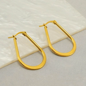 Elegant U-shaped golden stainless steel earrings displayed on a white marble pedestal