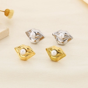 Detail of gold and silver lip-shaped stud earrings with embedded white pearls