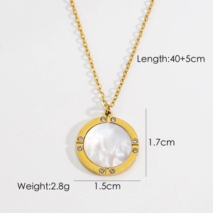 Detail view of gold necklace pendant with white mother of pearl and small rhinestones