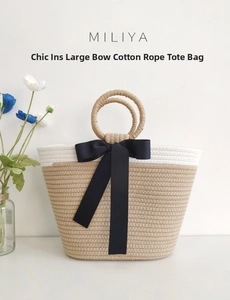 Detail of hand-woven cotton rope tote with cream wood tones and large black bow accent