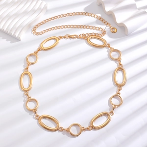 Close-up of golden multi-link metal waist chain with polished rings and lobster clasp